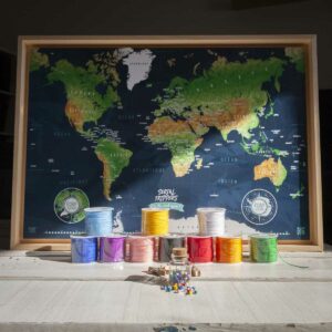 Carte du monde épingable Serial Trippers version sombre avec épingles et ficelles colorées